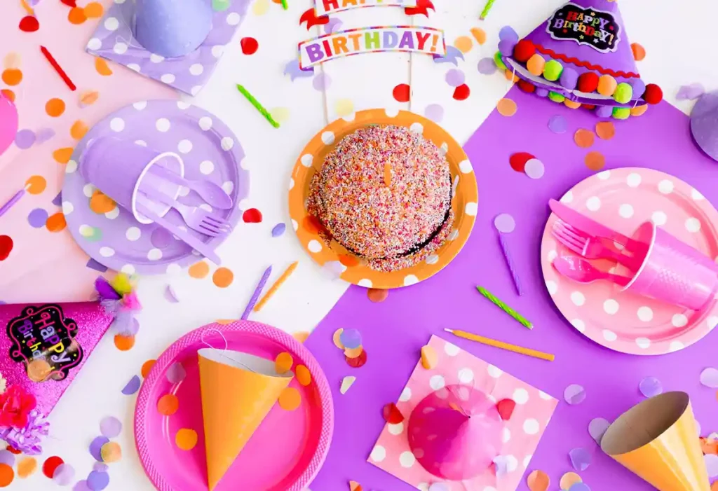 Top view on a table where sits colorful birthday related objects
